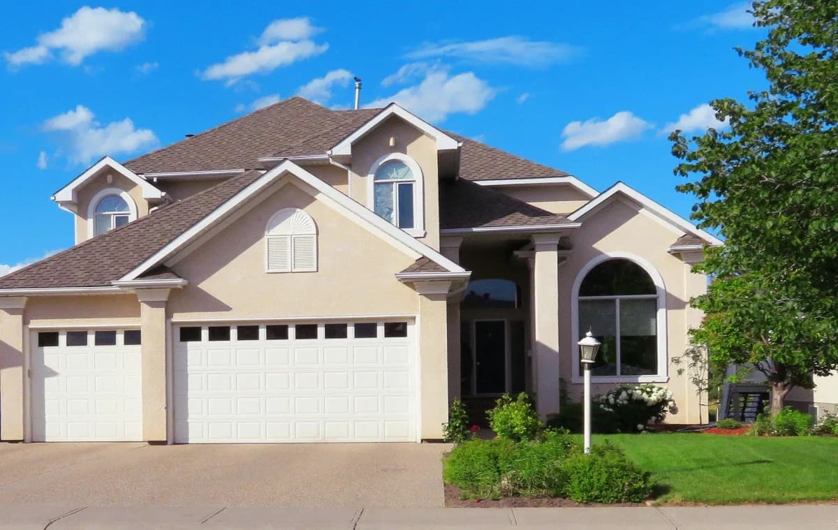 Suburban home with three-car garage and arched window