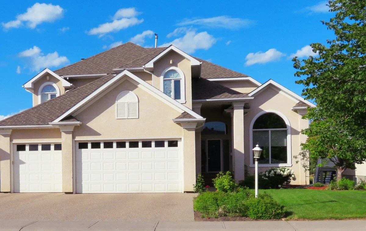 Suburban home with three-car garage and arched window